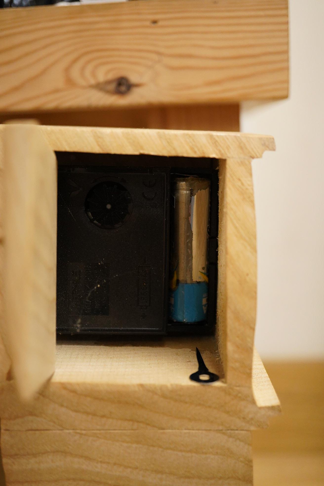 Pierre Decorse (b.1953), a naturalistically modelled wooden sculpture of a grandfather clock and a figure, together with two other sculptures comprising a suitcase and figure, largest 42cm high